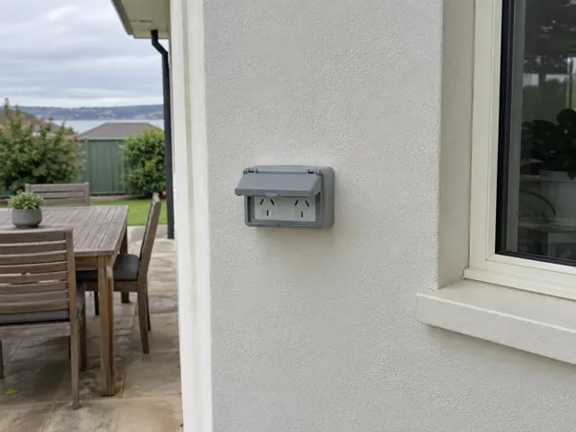 Outdoor double power point on a rendered exterior wall beside a patio and window in Boolaroo